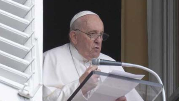 Pope Francis speaks to visitors from the window of his studio