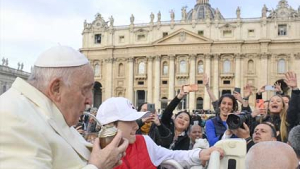 Pope Francis drinks mate, the traditional Argentine herbal tea, handed to him by a person in the crowd as he rides around St. Peter's Square at the Vatican in the popemobile before his weekly general audience April 5, 2023.