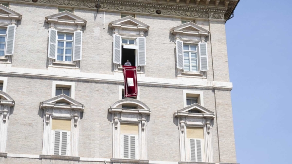 Pope Francis stands in the window of his studio in the Apostolic Palace at the Vatican