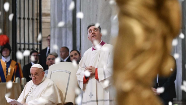 Pope Francis and an aide watch as white rose petals fall from the ceiling of Rome's Basilica of St. Mary Major