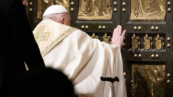 Pope Francis pushes open the Holy Door of St. Peter's Basilica at the Vatican Dec. 24, 2024